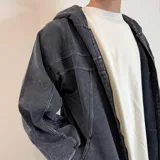 Campera con capucha de algodón color gris oscuro con efecto lavado y cierre frontal. Tiene bolsillos laterales y puños ajustados.