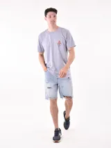 Remera gris con estampado pequeño en el pecho que incluye una montaña, un sol y olas.