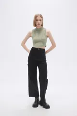Chaleco verde pálido de punto con cuello alto y diseño trenzado.