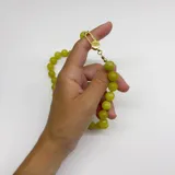 Collar elaborado con bolitas de Jade Limón de 10 mm de diámetro, ensartadas con hilo color salmón que forma nuditos separadores. Cuenta con un broche tipo langosta y terminaciones en acero con baño de oro.