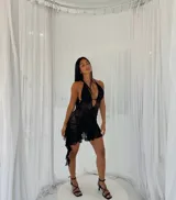 Vestido corto negro de encaje con escote halter y espalda descubierta.