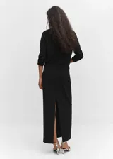 Jersey negro de punto fino con cuello alto, manga larga y terminaciones de canalé.