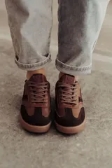 Zapatillas bajas de cuero color marrón con suela de goma color caramelo y cordones marrones.