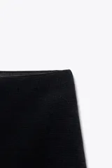 Minifalda negra de punto con cintura elástica.