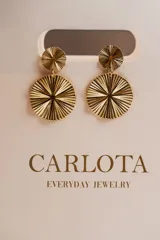 Aros colgantes dorados con diseño circular texturizado.