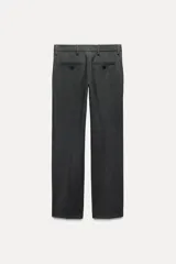 Pantalón de vestir gris oscuro de tiro bajo, con trabillas en la cintura, bolsillos delanteros y traseros, raya planchada y pierna recta.