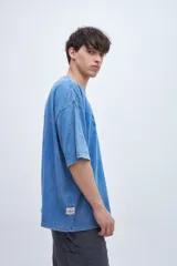 Remera celeste con efecto marmolado y estampa en el pecho, de corte boxy y mangas cortas.