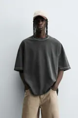 Camiseta color beige de corte holgado, cuello redondo y manga corta.