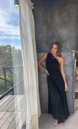 Vestido largo negro de un solo hombro, confeccionado en tela tableada con sutiles brillos.