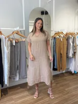 Vestido midi azul marino de lino, corte recto, con cuello en V, mangas cortas y detalle de flecos en ruedo y mangas.