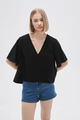 Blusa color crema de viscosa con escote en V y mangas cortas acampanadas.