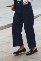 Pantalón de jean azul oscuro, de tiro alto y corte recto con pernera ancha.