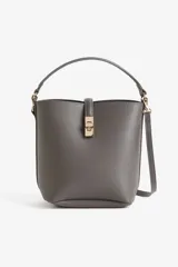 Cartera gris tipo bucket con asa corta y correa larga extraíble. Tiene cierre con trabilla y herraje metálico dorado. Interior forrado.