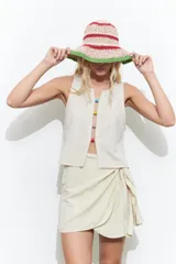 Minifalda color beige con diseño cruzado y nudo lateral.