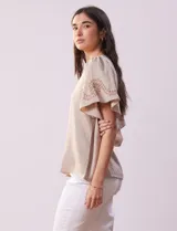 Blusa color beige de crepe, marca Batía, con cuello a la base y escote en V. Manga corta amplia con bordados.