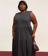Vestido midi gris sin mangas, con cuello redondo, corte recto y volados en la falda.