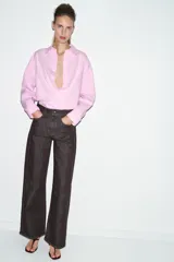 Jeans de tiro medio, color negro lavado con efecto desgastado, corte recto y holgado (loose straight), con cinco bolsillos y cierre frontal de cremallera y botón.