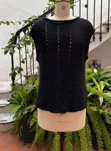 Chaleco color crudo tejido a mano en hilado 100% baby alpaca, con cuello tipo bote, hombros anchos, puntos calados en frente y espalda, y tajos laterales en el bajo.