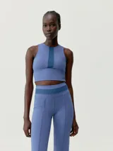 Top deportivo cropped color celeste con panel frontal en azul marino.