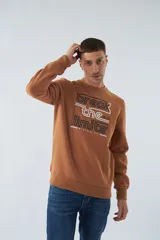 Buzo marrón de felpa con cuello redondo, mangas largas y puños. Estampado frontal con la frase "break the limits" y logo de la marca Mistral.