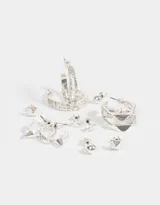 Set de aros plateados con seis pares de aros pasantes con diferentes diseños: bolitas, púas, cruces y argollas con púas, dobles y orgánicas.