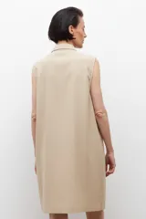 Vestido negro sin mangas con cuello camisero y cierre frontal con cordones. Presenta dos bolsillos con solapa a la altura del pecho y dos bolsillos laterales a la altura de la cadera.