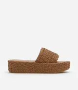 Sandalia flatform color marrón con superficie trenzada, tira ancha, puntera redonda y plataforma de 5 cm.