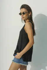 Blusa negra sin mangas con escote en V y abertura en el centro.