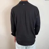 Camisa de lino color verde militar, de manga larga con puños abotonados y cuello clásico. Cierre frontal con botones.