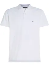 Chomba blanca de piqué de algodón elástico, corte slim, cuello de chomba, cartera de tres botones y logo de Tommy Hilfiger bordado en el pecho.