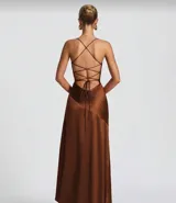 Vestido largo color verde oliva, de satén, con escote drapeado, tirantes finos, fruncido en la cintura, falda asimétrica con volados y abertura lateral.