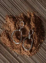 Aros colgantes plateados con forma irregular.