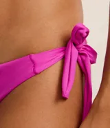 Bombacha de bikini fucsia con lazos gruesos en los laterales y corte hilo doble en la parte trasera.