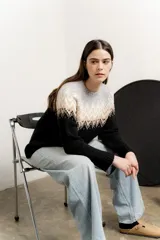 Sweater de punto con cuello redondo, mangas largas y diseño de guardas geométricas en tonos gris, beige y blanco en la parte superior, y negro en la parte inferior.