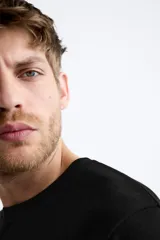 Jersey de punto color marrón oscuro, de corte relajado (relaxed fit), con cuello redondo y manga corta.