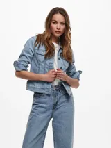 Chaqueta de jean celeste de corte clásico, con mangas largas con puños abotonados, cierre frontal con botones metálicos y bolsillos delanteros con solapa y botón.