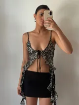 Top de fiesta negro con lentejuelas plateadas, escote en V y tirantes finos.