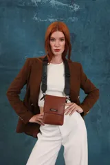 Bandolera tipo phone bag pequeña, color marrón claro, con correa de galón regulable. Tiene un compartimento principal y un bolsillo adicional con tapa.