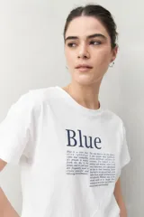 Remera blanca de manga corta con estampado tipográfico azul en el frente.