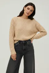 Sweater de algodón color beige, con tejido de punto crochet, cuello bote y diseño holgado de manga larga.