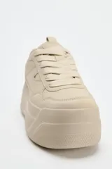 Zapatillas deportivas color beige con plataforma de 6 cm y cierre con cordones.