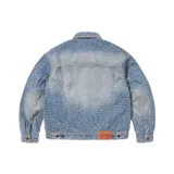 Campera de denim azul con estampado de la palabra "Fuck" repetida en toda la prenda. Tiene cuello clásico, cierre con botones metálicos, dos bolsillos con solapa en el pecho y puños abotonados.
