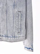 Campera de jean negra con botones metálicos, bolsillos frontales con solapa y cuello clásico.
