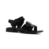 Sandalias bajas de cuero charol negro, con tiras anchas cruzadas en el empeine y hebilla lateral ajustable.