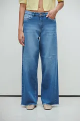 Pantalón de jean azul de tiro medio/bajo, con calce extra relaxed y piernas anchas. Confeccionado en denim rígido liviano, con lavado acid wash azul y desflecado en ruedos.