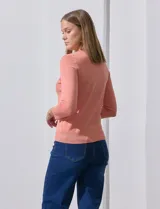 Cardigan tejido en hilado fino, color rosado, con escote redondo y cierre frontal con botones.