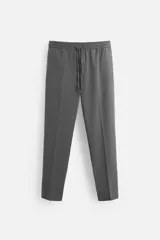 Pantalón gris de corte recto con cintura elástica ajustable con cordón, bolsillos laterales y detalle de bolsillos de vivo en la espalda.