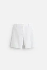 Bermuda blanca regular fit confeccionada en tejido con algodón y lino. Con bolsillos frontales y traseros. Cierre frontal con cremallera y botón.