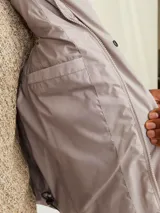 Chaleco acolchado sin mangas color gris claro, con cuello alto y cierre de cremallera. Tiene bolsillos frontales y forro de poliéster reciclado, con relleno de poliéster reciclado.