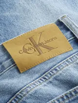 Pantalón de jean celeste de corte slim recto, con tiro medio, cinco bolsillos y cierre con cremallera.
